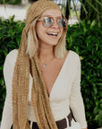 Model wearing the golden textured handwoven scarf as a head scarf