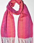 Fuchsia handwoven scarf draped on a white table. Check out the block pattern.