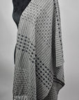 A full view of the gray handwoven scarf draped over a mannequin.