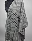 Another view of the handwoven women's gray shawl draped over a mannequin.