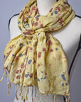 Bright yellow hand-painted cotton scarf on a mannequin