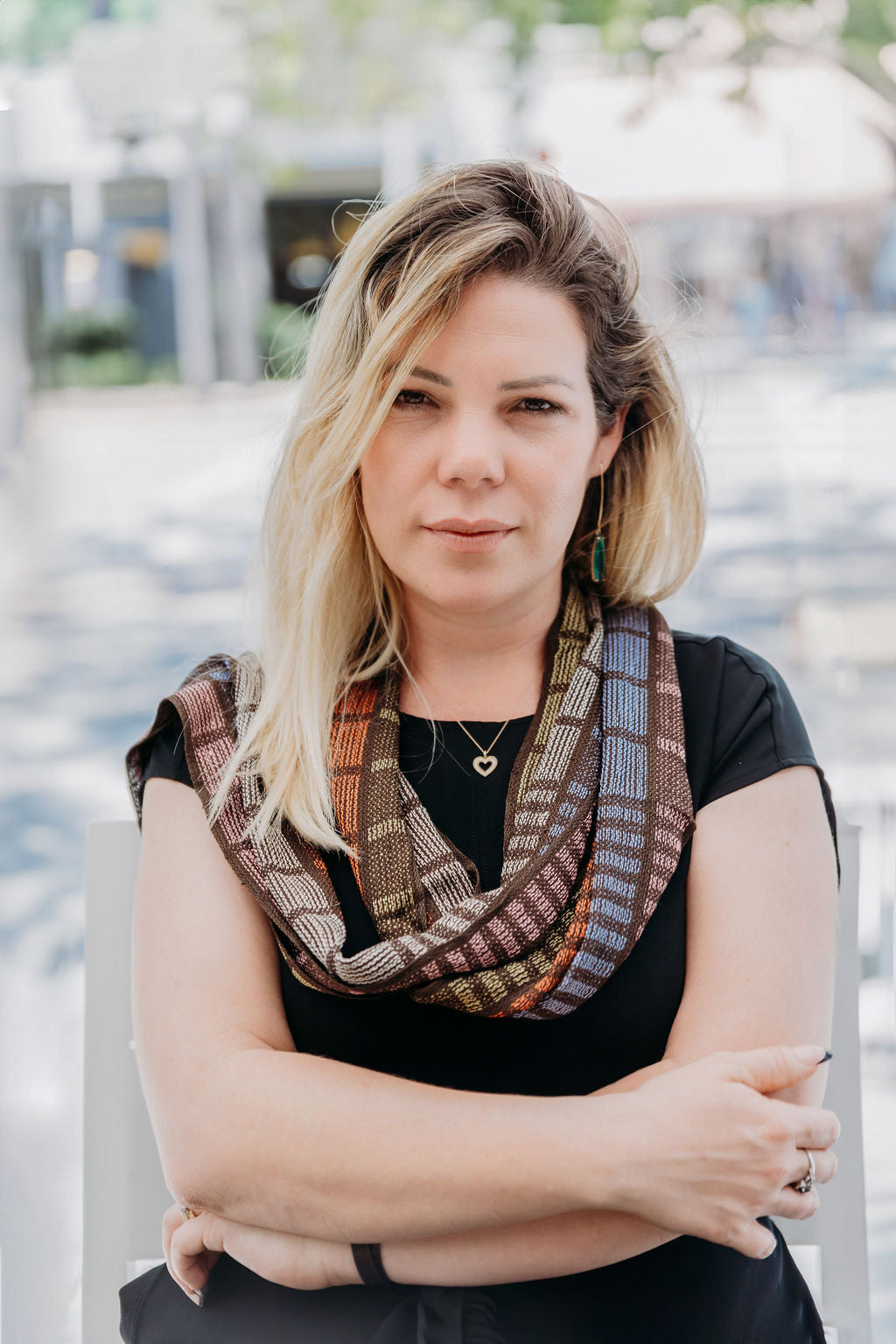 Rust brown with bright colors handwoven scarf draped on a model. 