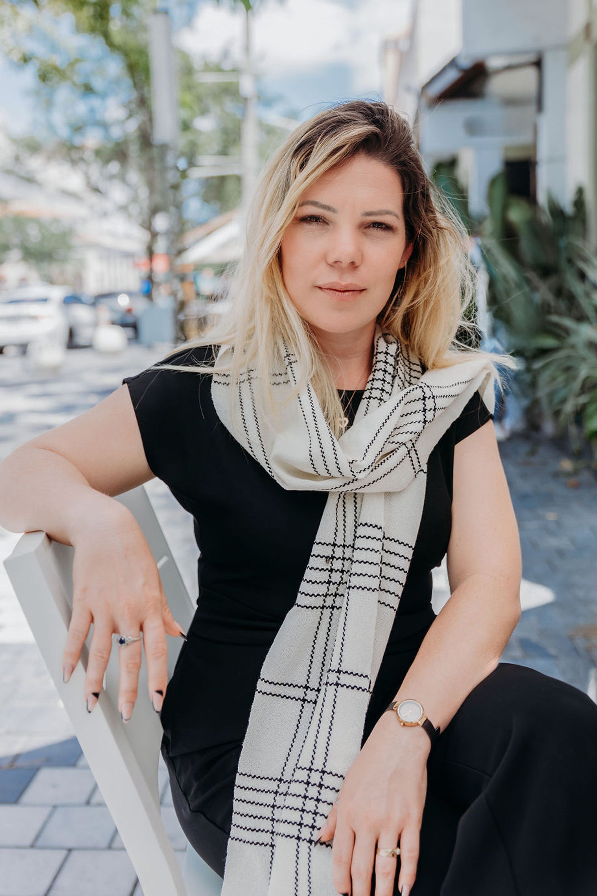 White handwoven wool scarf with black accents on a model.