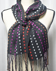 Black with orange, purple, red, and white handwoven scarf with up-cycled exclusive yarns on a mannequin