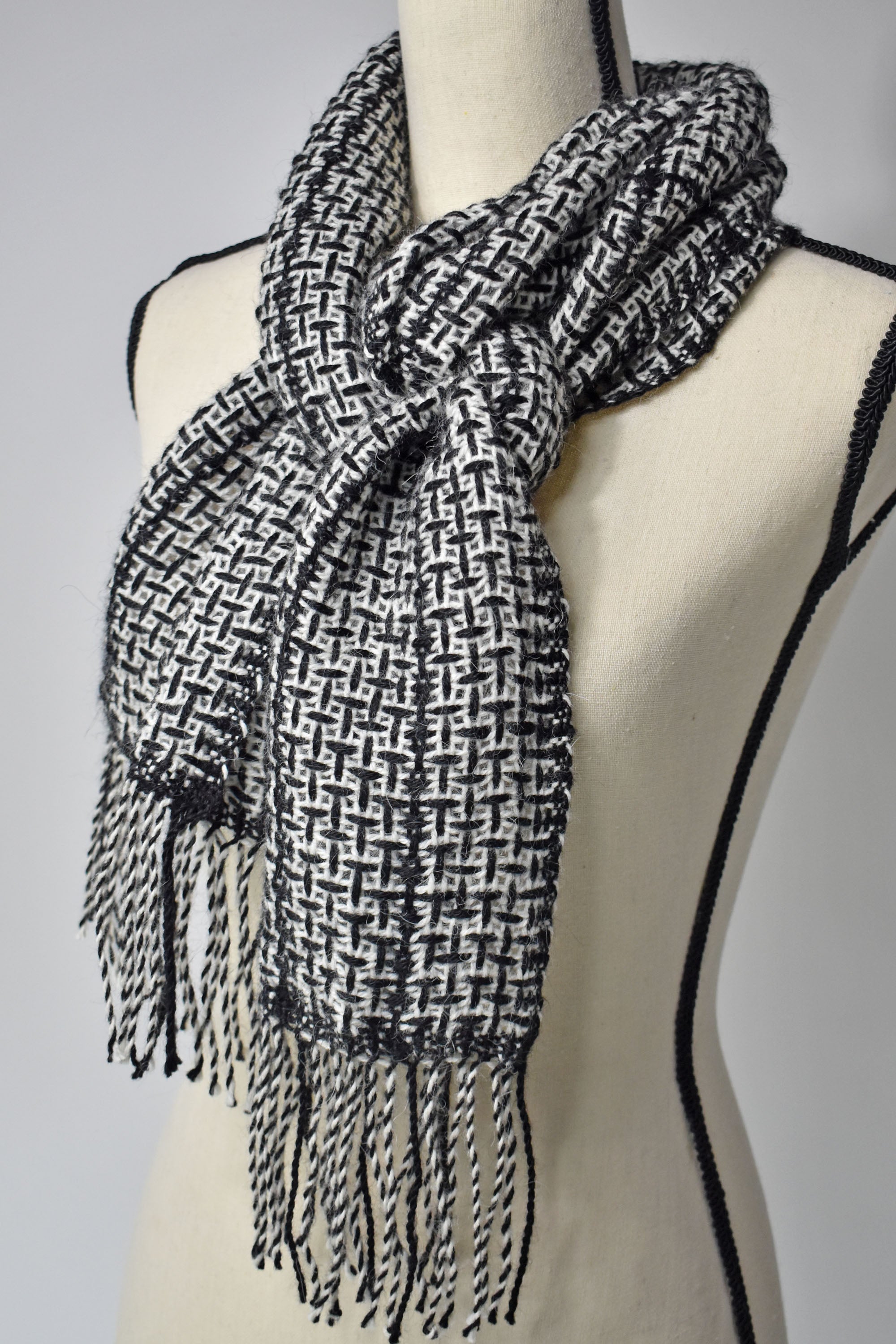 Black + white handwoven alpaca scarf on a mannequin