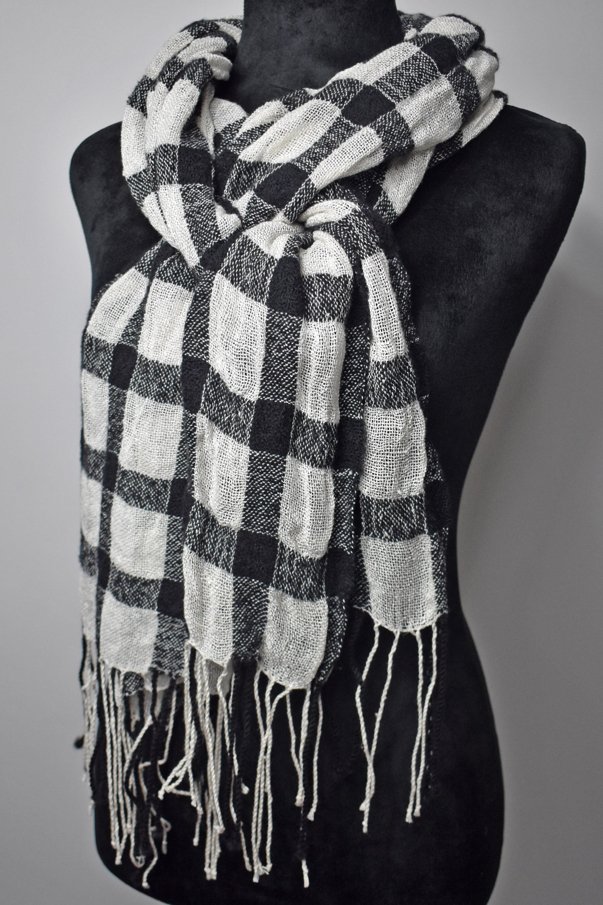 Black + white plaid merino wool scarf draped on a mannequin