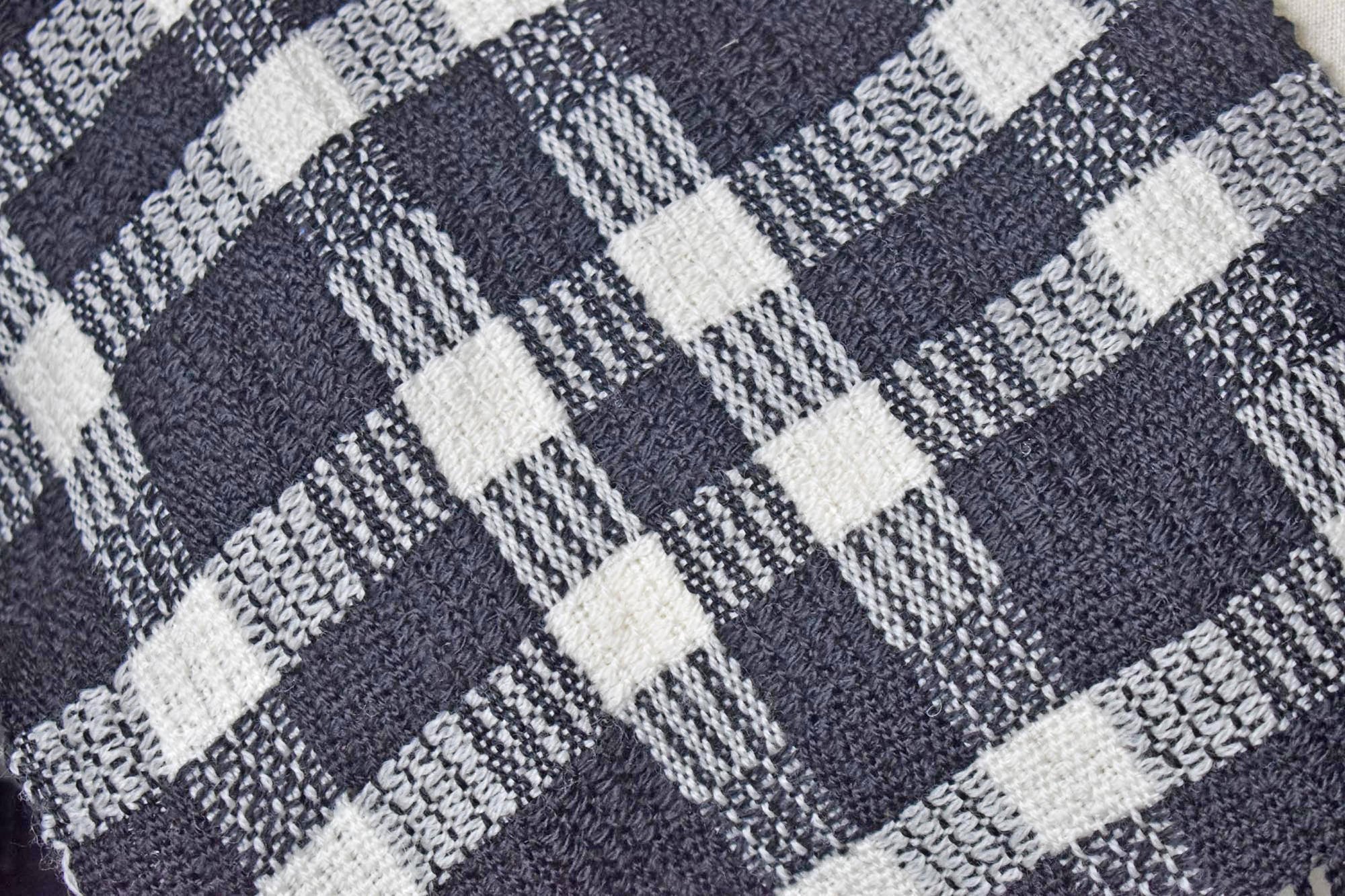 Close-up of the black + white handwoven merino wool scarf