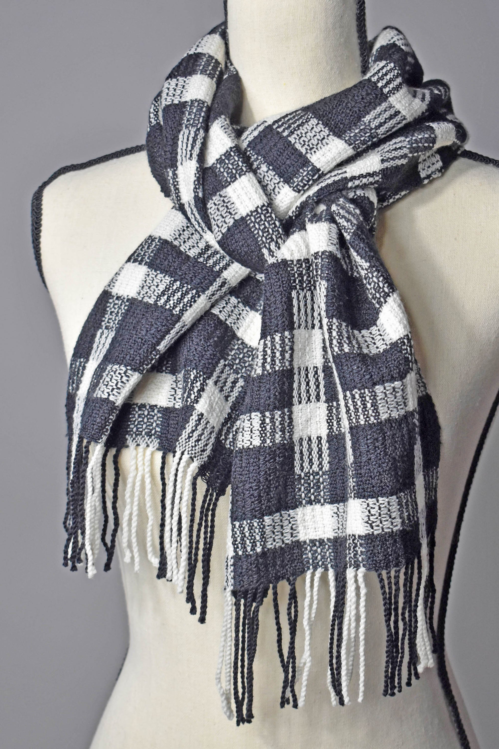 Black + white handwoven merino wool scarf styled on a mannequin