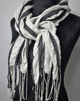 Black merino wool with white up-cycled yarns striped puckered scarf on a mannequin.