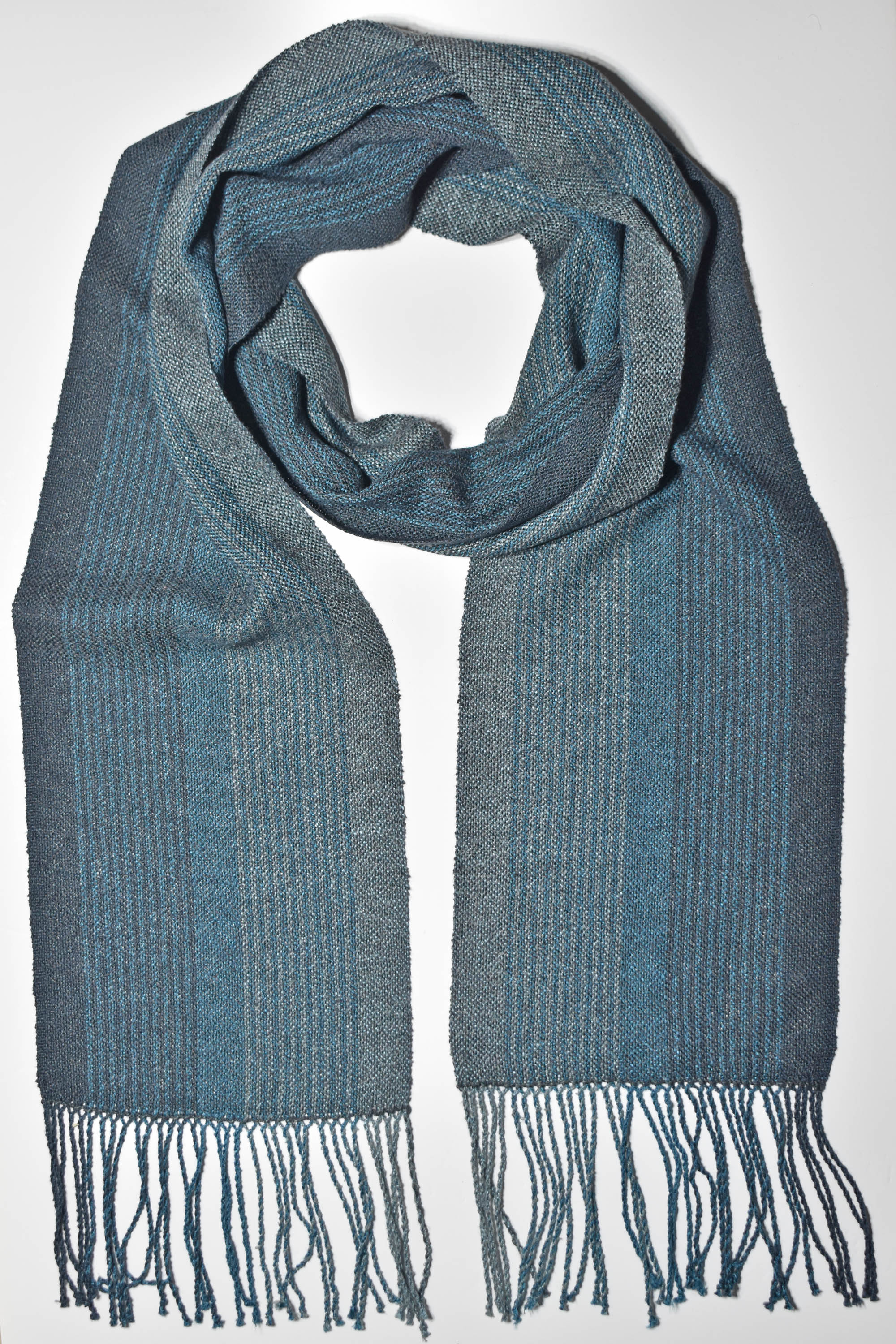 Blue + green handwoven scarf styled on a white table