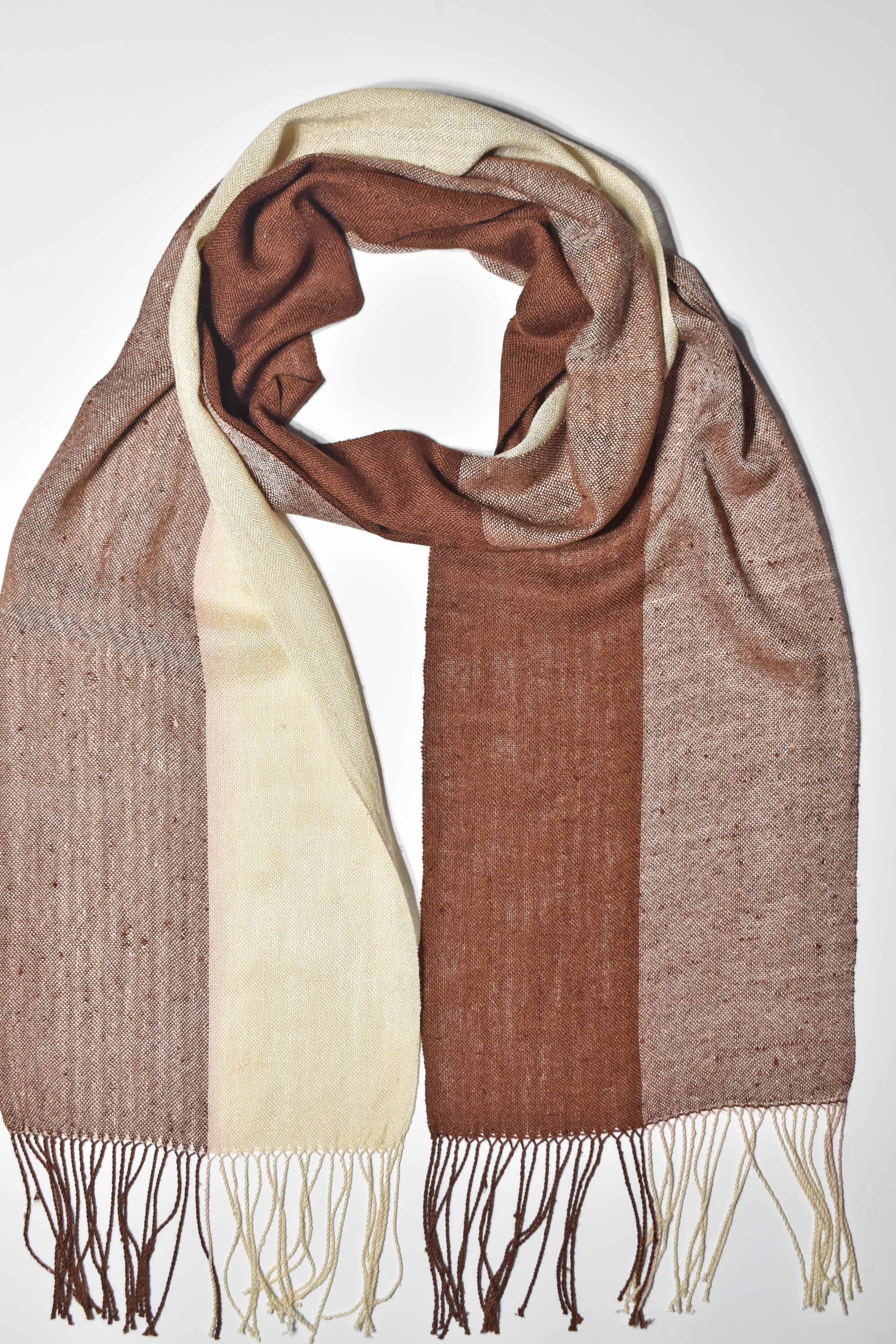 Brown + cream striped handwoven scarf styled on a white table