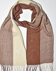 Brown + cream striped handwoven scarf styled on a white table