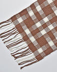 Close-up pf the hand twisted fringe on the chestnut brown + white handwoven wool scarf