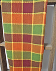 Fall inspired handwoven organic cotton towel hanging on a wooden ladder