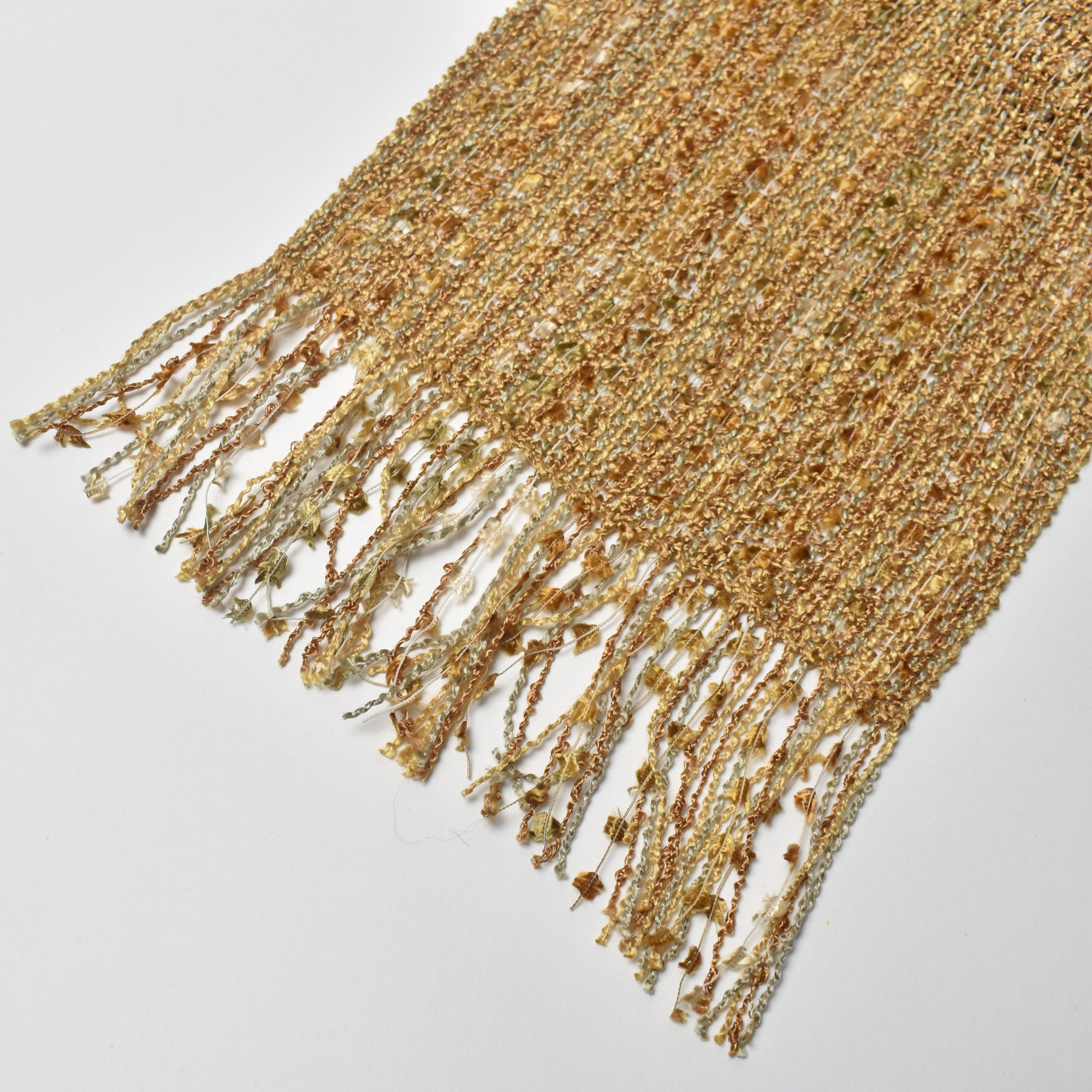 Close-up of the eyelash fringe on the golden textured handwoven scarf