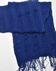 Bird's eye view of the indigo blue handwoven scarf styled on a white table