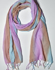 Blue, pink, and brown hand-painted cotton scarf wrapped on a white table