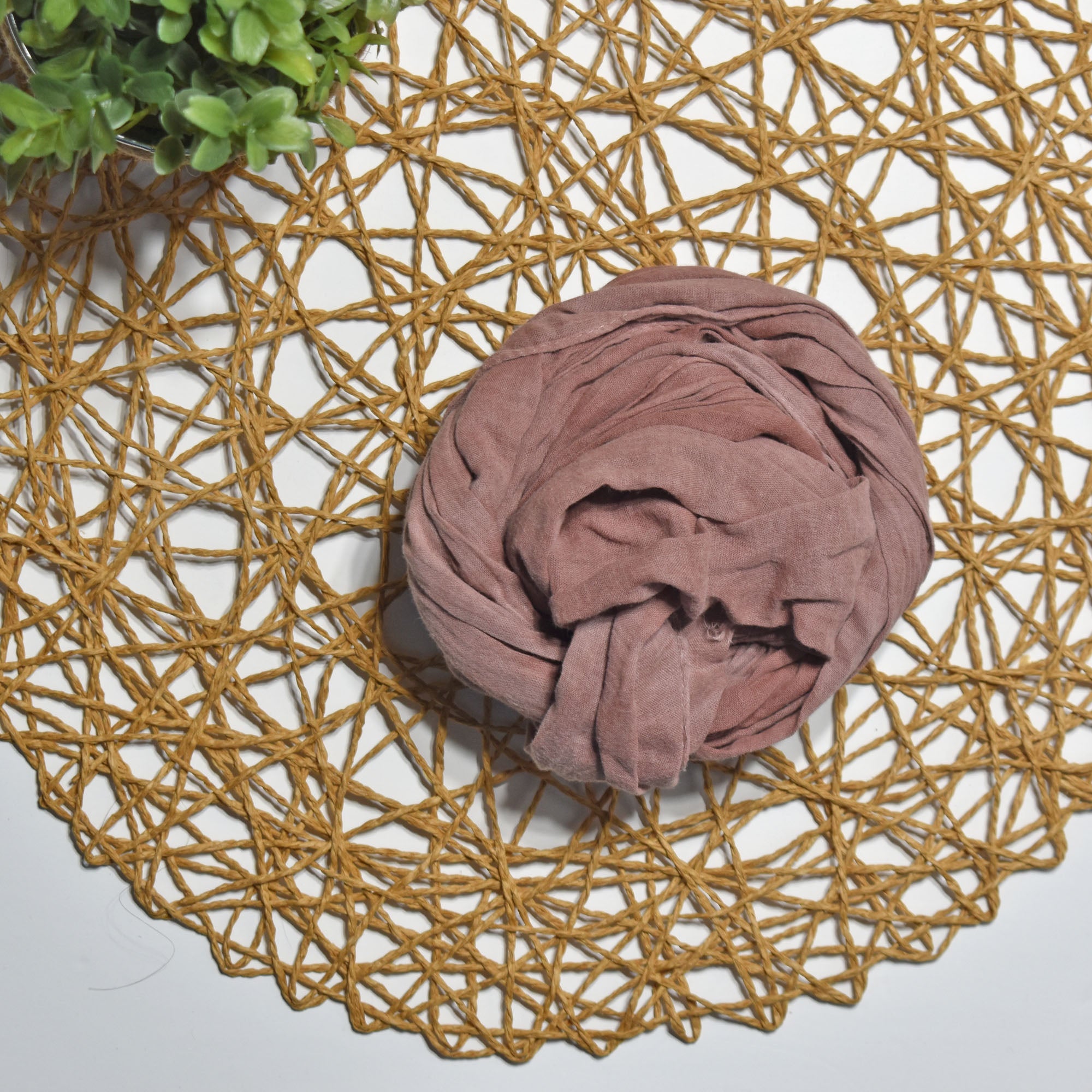 Hydrangea color hand-painted scarf on a white table with a plant and rattan doily