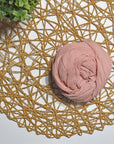 Rose hand-painted scarf on a white table with a plant and rattan doily