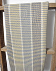 Hanging on a wooden ladder is a neutral handwoven organic cotton dish towel