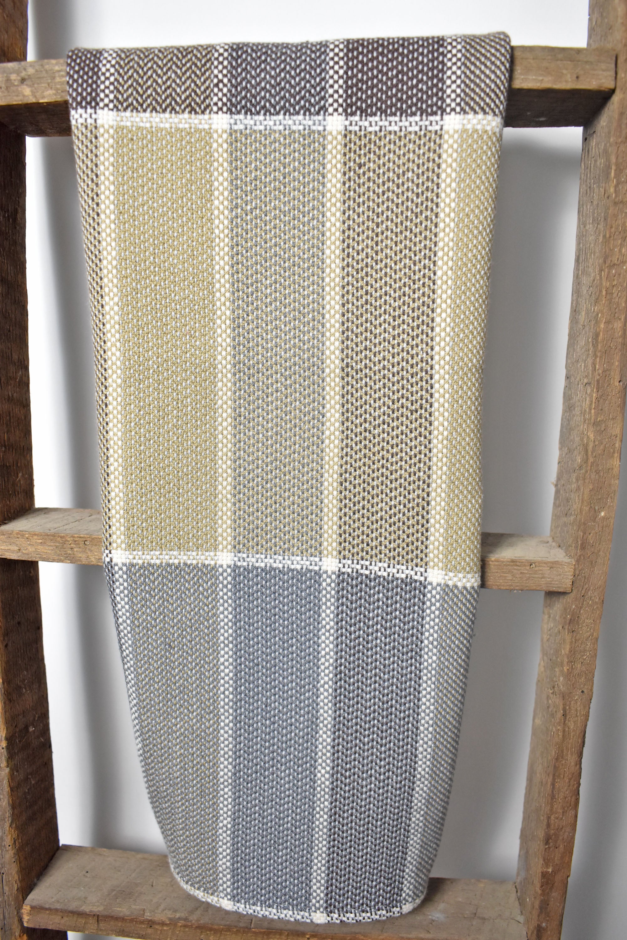 Plaid handwoven cotton tea towel hanging on a wooden ladder