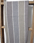 Neutral handwoven tea towel draped over a wooden ladder