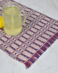 Patriotic placemat on a white table with a lemon and a glass of lemonade on top. Eucalyptus is view.