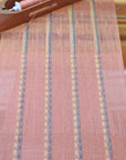 A close-up of the peach scarf on the floor loom as it is woven