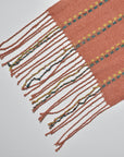 Close-up of the hand twisted fringe on the peach handwoven scarf