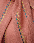 Close-up of the peach handwoven scarf on a model