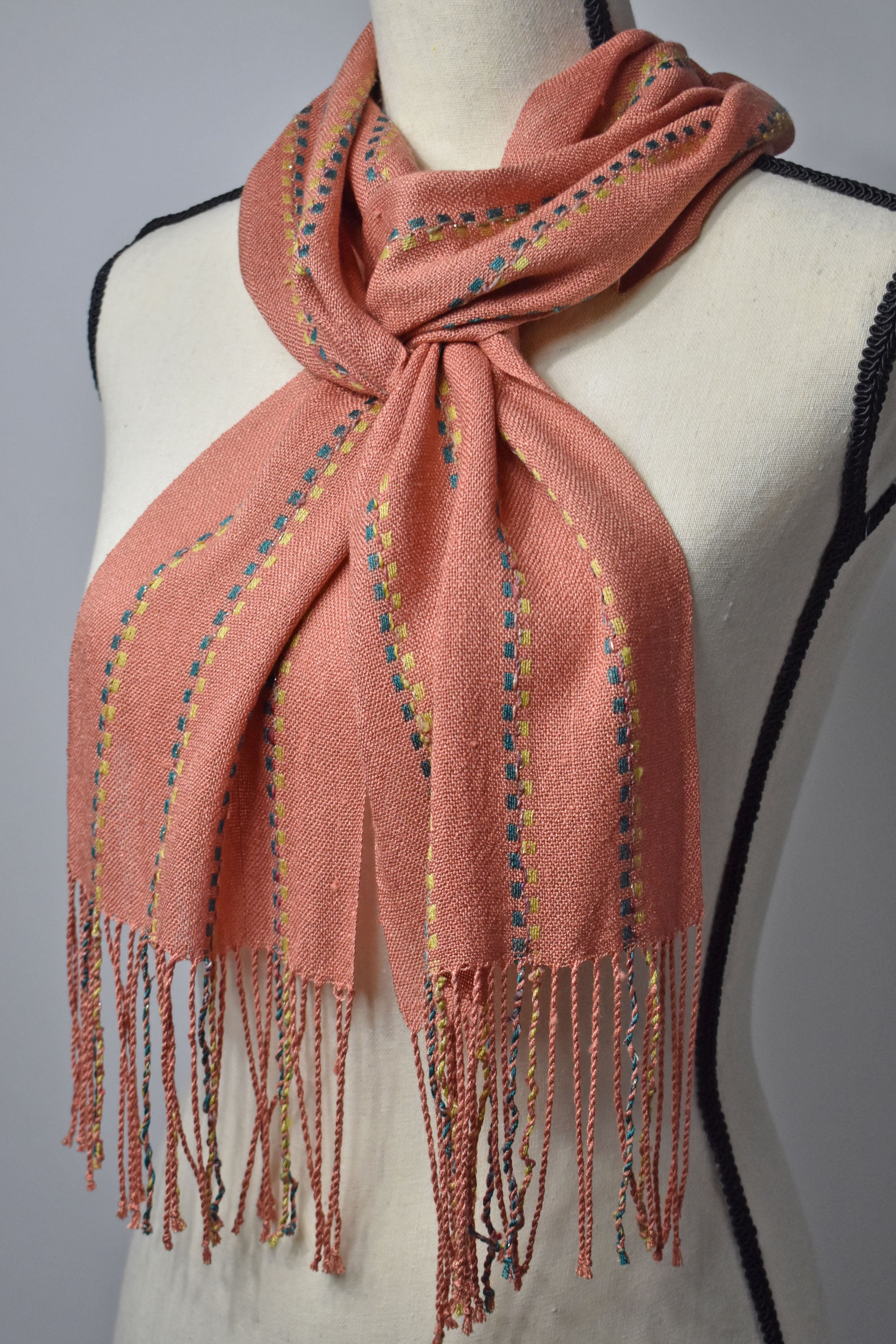 Peach handwoven scarf made with up-cycled exclusive yarns on a mannequin