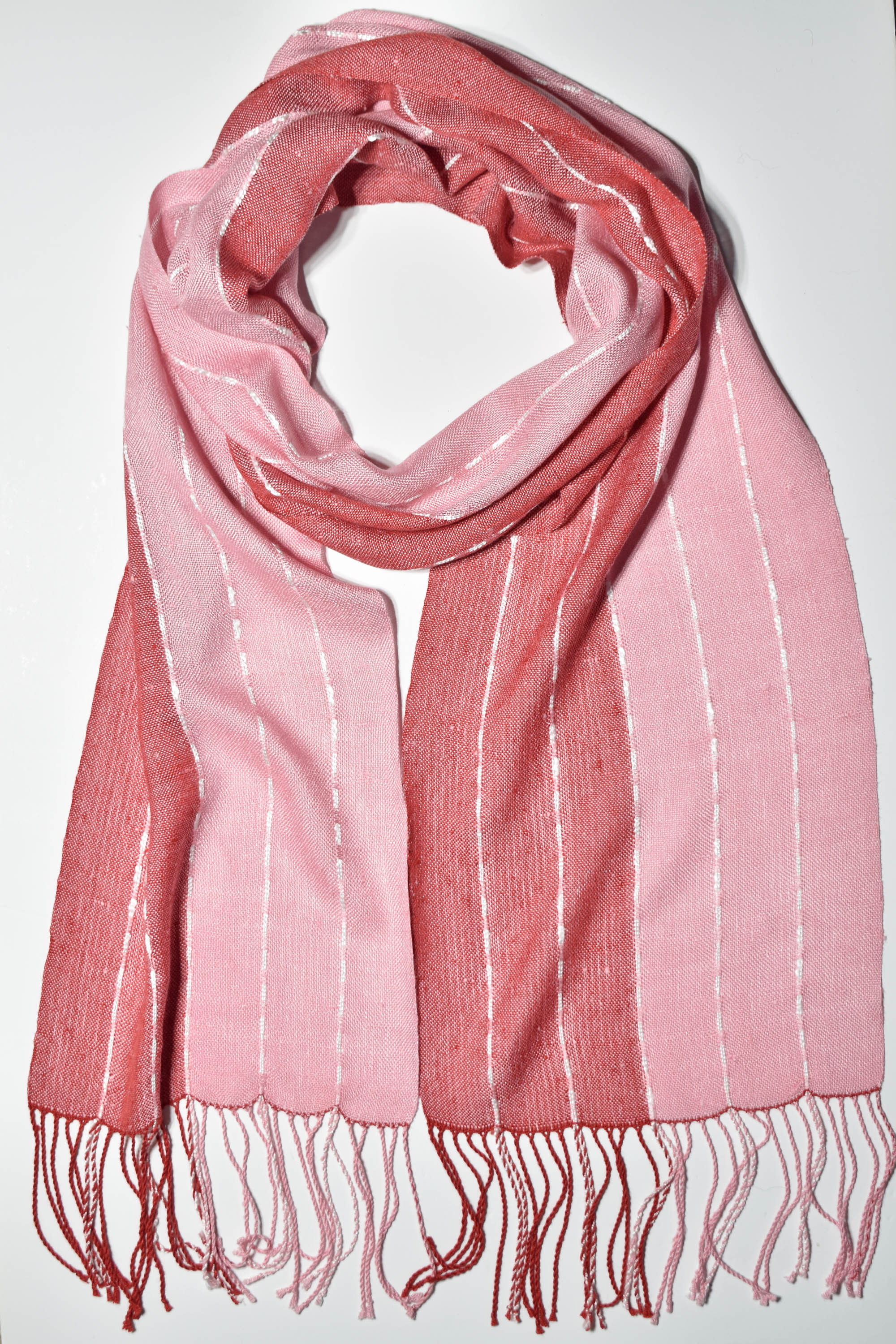 Pink + red handwoven scarf styled on a white table