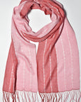 Pink + red handwoven scarf styled on a white table