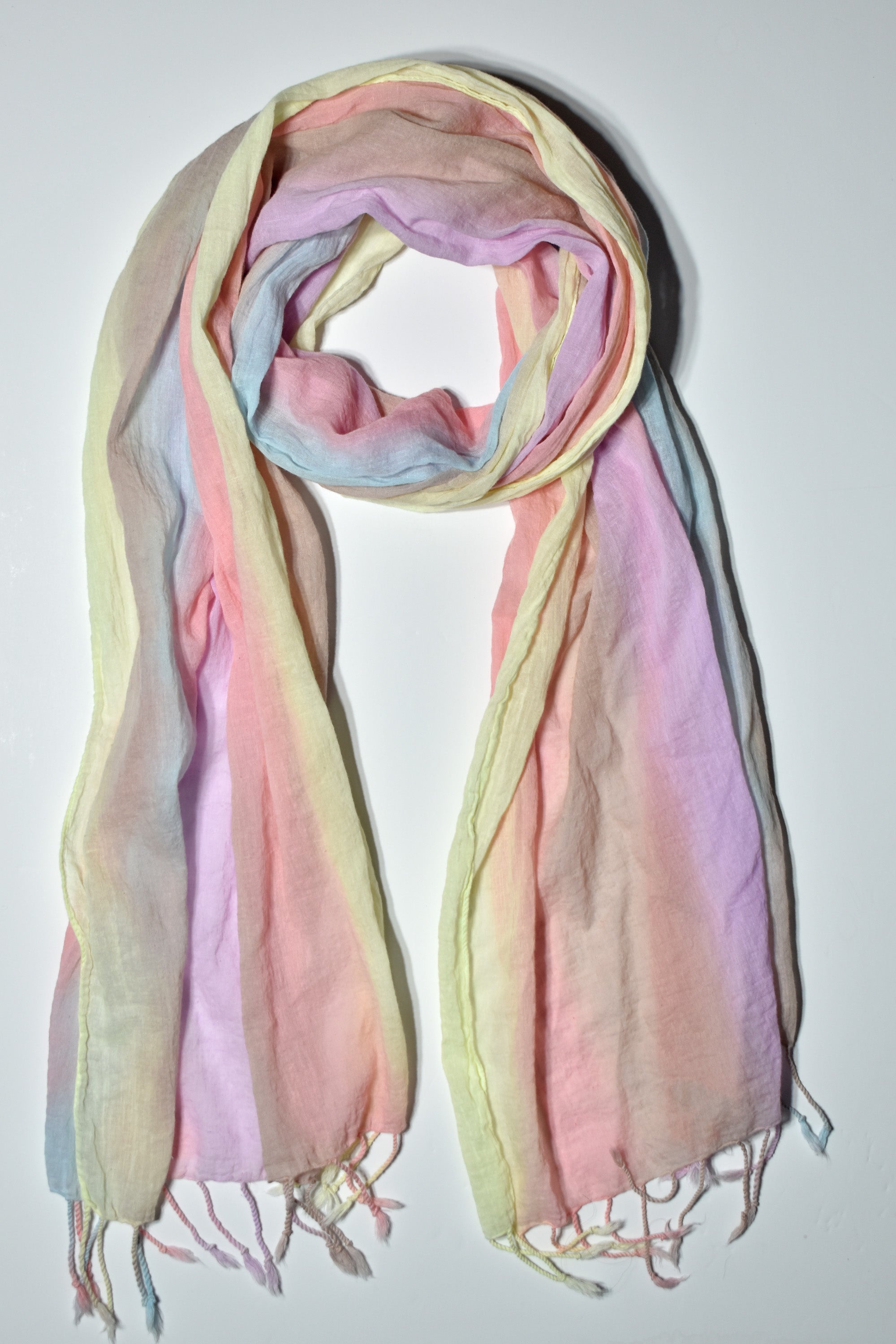 Pastel cotton scarf laying on a white table. 