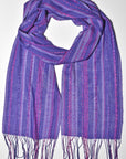 Purple handwoven scarf displayed on a white table