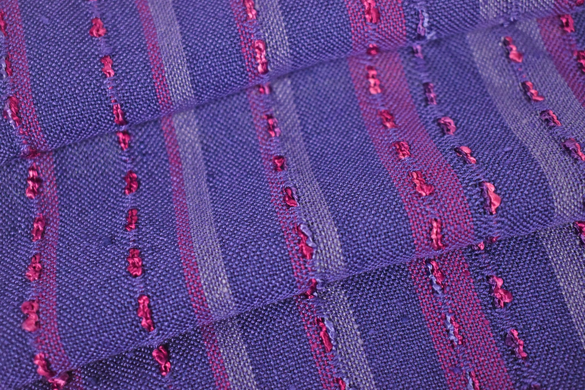 Close-up of handwoven purple scarf folded on a table