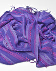 Purple handwoven scarf draped on a white table