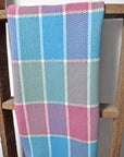 Spring inspired plaid towel draped over a wooden ladder