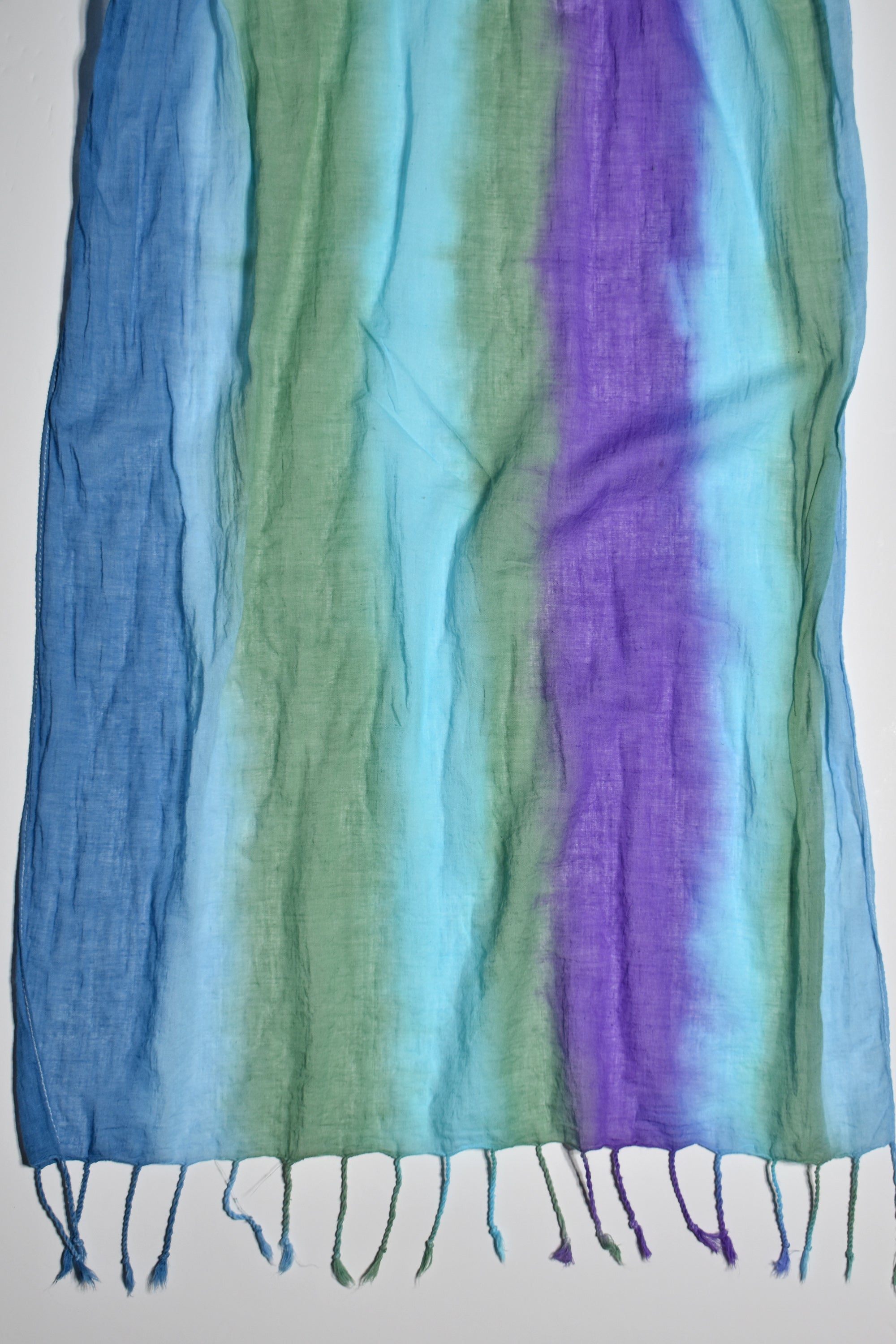 Close-up of the blue, green, and purple colors of the hand-painted cotton scarf