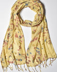 Yellow hand-painted scarf styled on a white table