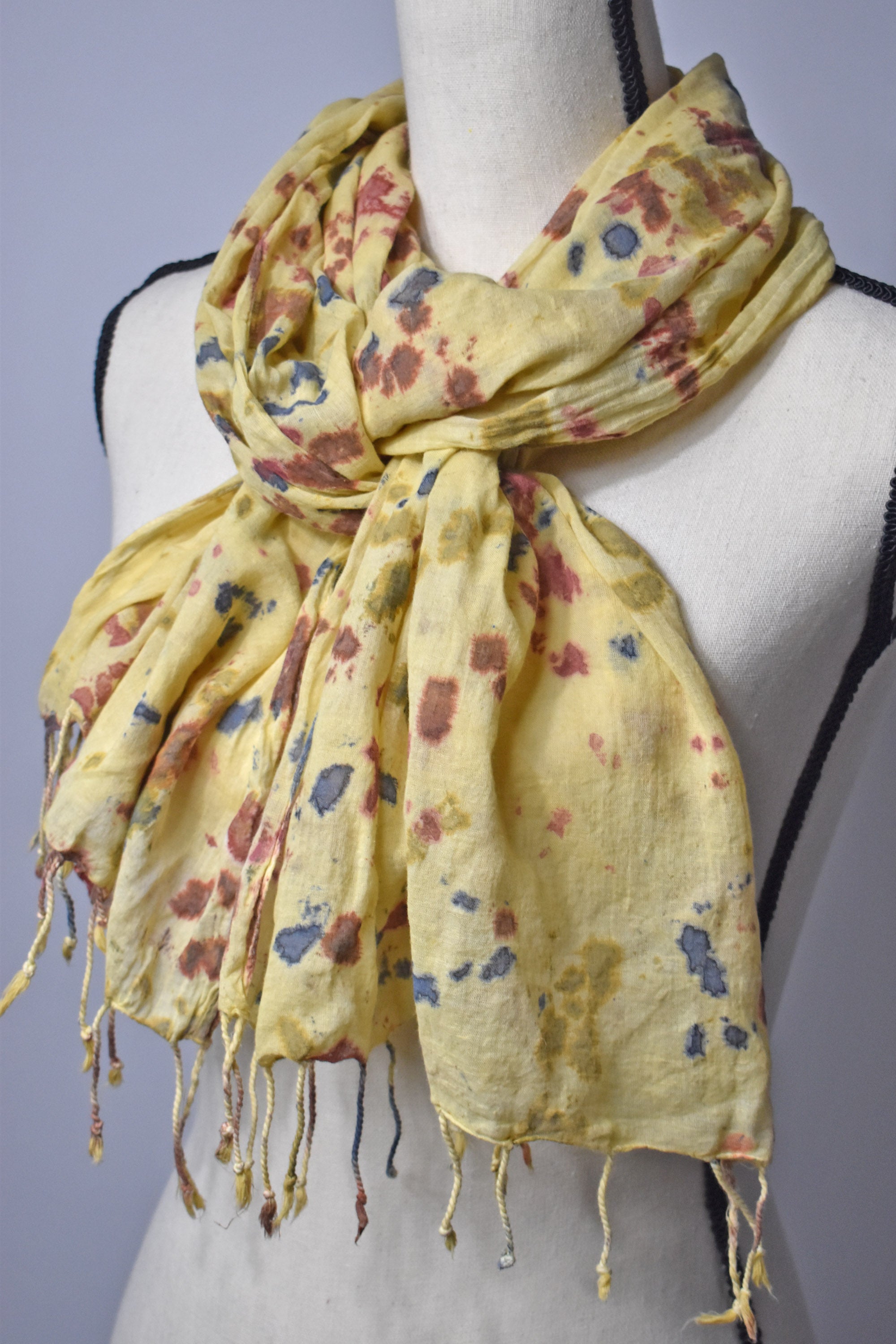 Bright yellow hand-painted cotton scarf on a mannequin