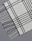 Close-up the hand twisted fringes on the white handwoven merino wool scarf