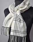 White handwoven merino scarf with black accents on a mannequin