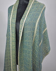 The women's handwoven scarf wrapped around the shoulders of the mannequin.