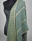 Blue and green shawl draped off the shoulder of the mannequin. Shows the two different sides of the fabric.