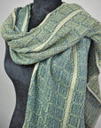 Women's handwoven blue and green scarf styled on a mannequin.