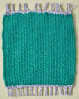 Handwoven mug rug in a solid green color placed on a yellow table.